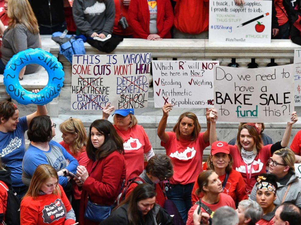 PHOTO: Teachers from across Kentucky hold up signs as they fill the state Capitol to rally for increased funding and to protest last minute changes to their state funded pension system, April 2, 2018, in Frankfort, Ky.