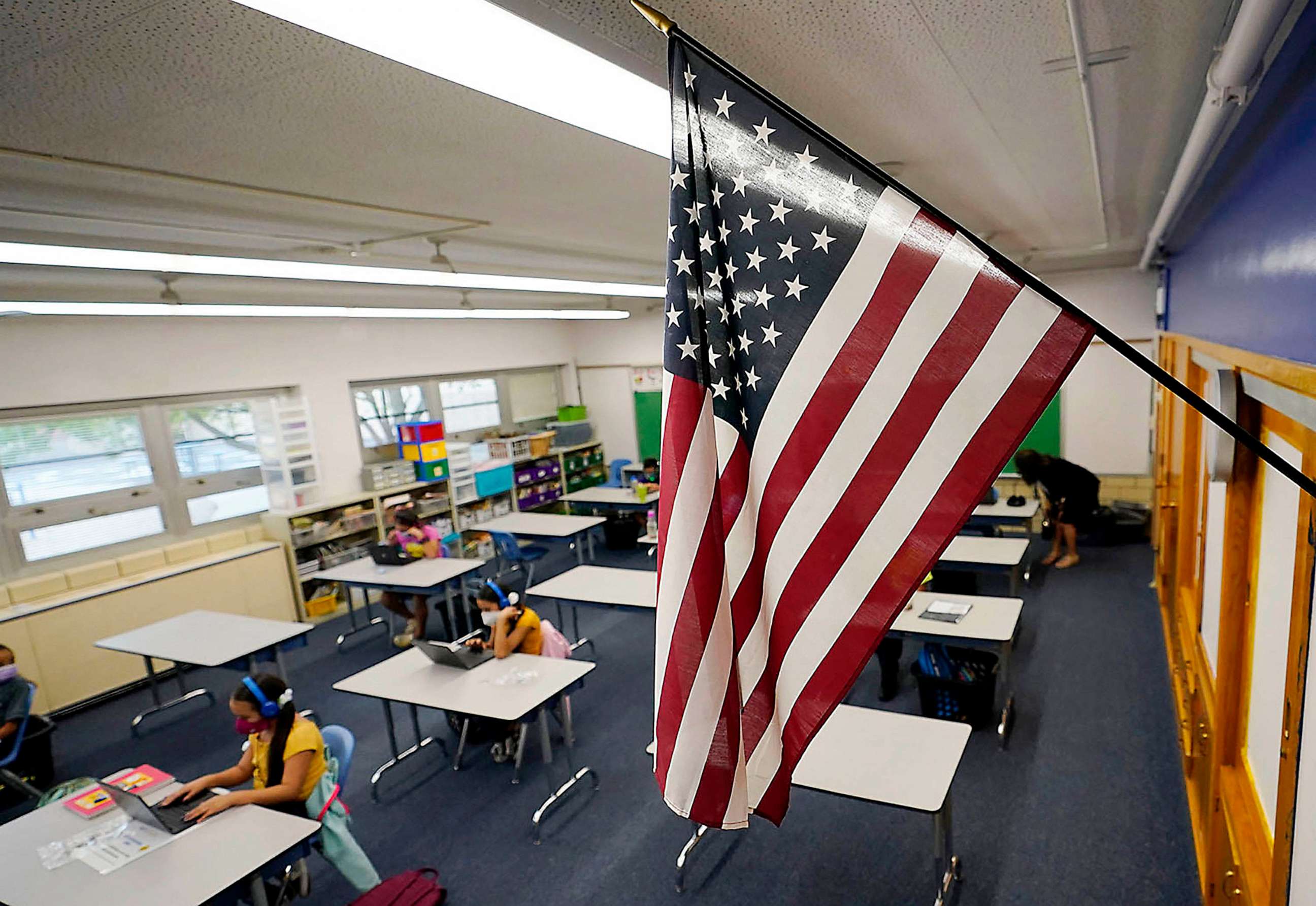 PHOTO: FILE - An American flag hangs in a classroom as students work on laptops in Newlon Elementary School, Aug. 25, 2020 in Denver.