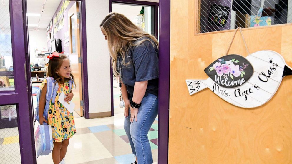 PHOTO: Kindergarten teacher Krystal Agee greets student Dailey Harrison as she arrives for class in Tuscaloosa, Ala., Aug. 10, 2022.