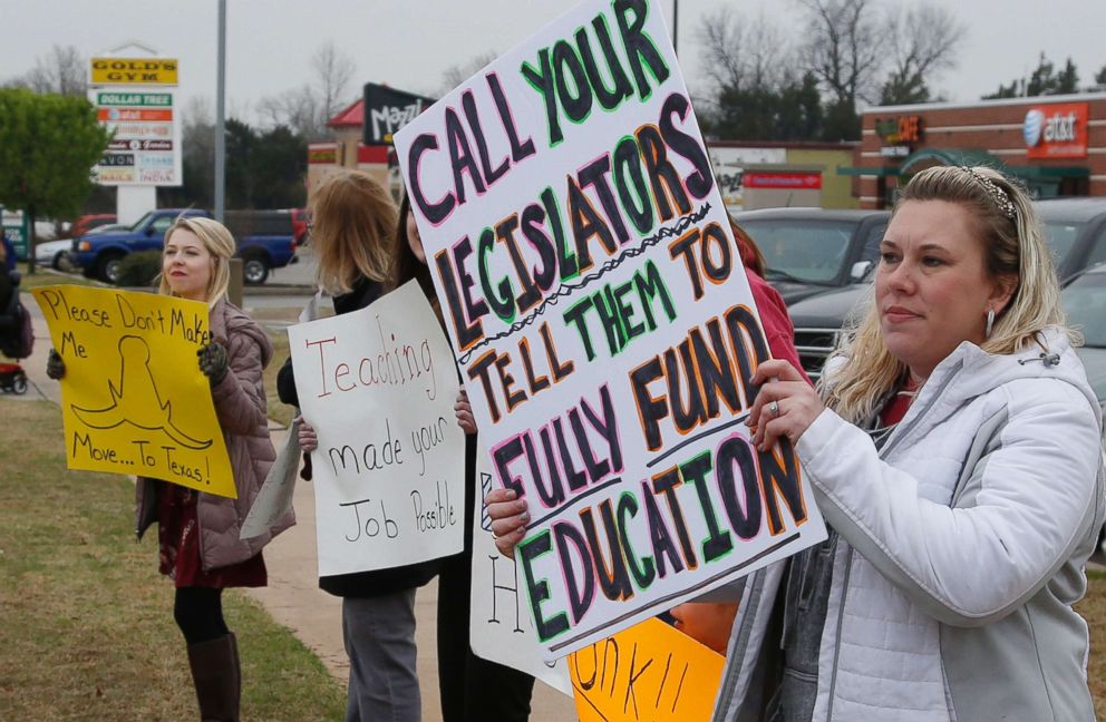 PHOTO: Teacher Adrien Gates pickets with other educators on a street corner in Norman, Okla., March 27, 2018.