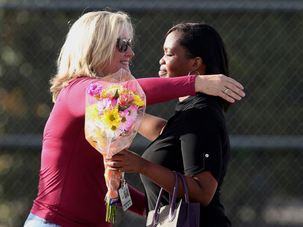 PHOTO: Marjory Stoneman Douglas High School assistant principal Denise Reed hugs a school employee as she returns to the school, Feb. 23, 2018. 