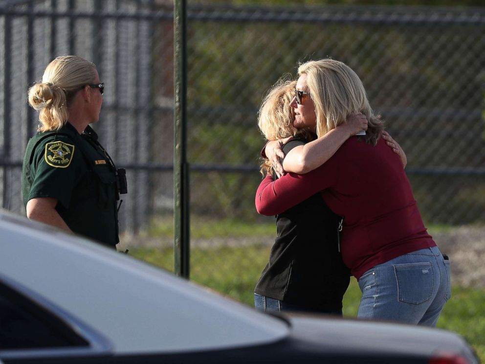 PHOTO: Assistant Principle Denise Reed (R) hugs a school employee as teachers and staff are allowed to return to the school for the first time since the mass shooting on campus on Feb. 23, 2018 in Parkland, Florida.