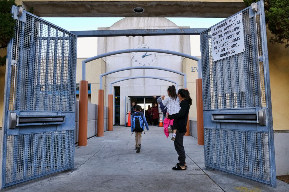 PHOTO: Parents and toddler wave to children as they return to the Evelyn Thurman Gratts Elementary School in downtown Los Angeles, Jan. 23, 2019, following a city wide teachers' strike.