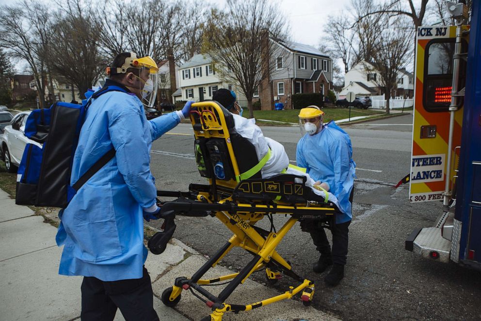 PHOTO: Emergency medical technicians transport a patient on a stretcher towards an ambulance, at a scene in Teaneck, N.J., April 10, 2020.