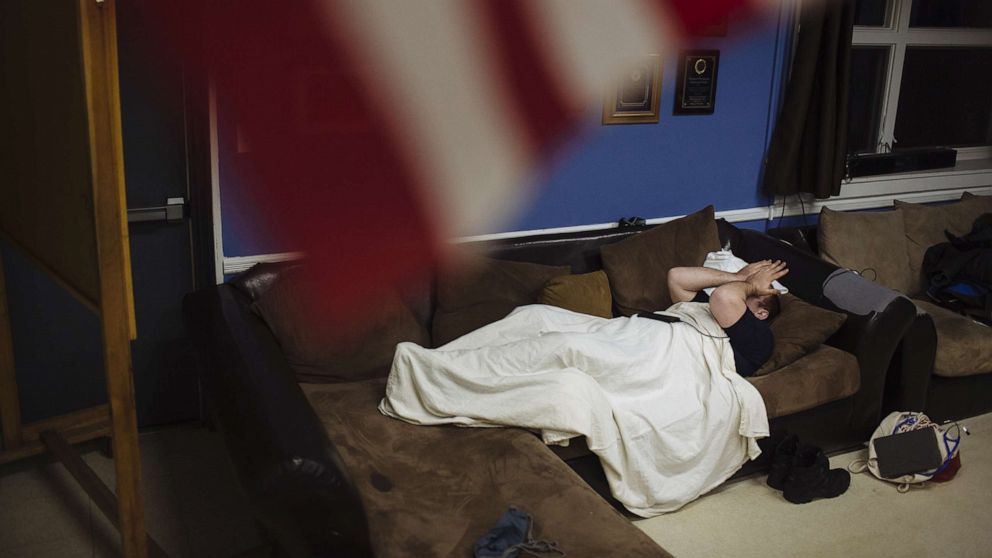 PHOTO: An emergency medical technician rubs their face while resting between calls, at an ambulance station house in Teaneck, N.J., April 10, 2020.