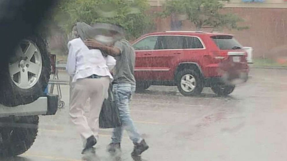 PHOTO: An officer snapped a photo of a young man getting out of his car to help shield a woman from the rain.