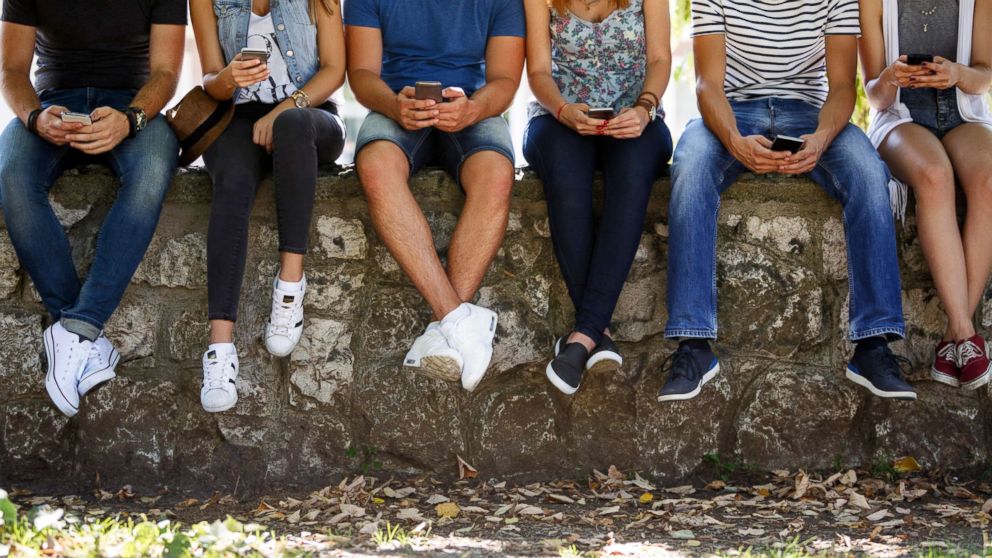 PHOTO: A group of teenagers are pictured texting on their phones in this undated stock photo. 