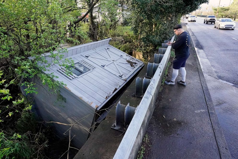 PHOTO: Adam Wirdzek stops to look at a utility building that was carried down a flooded creek, March 28, 2021, in Nashville, Tenn.