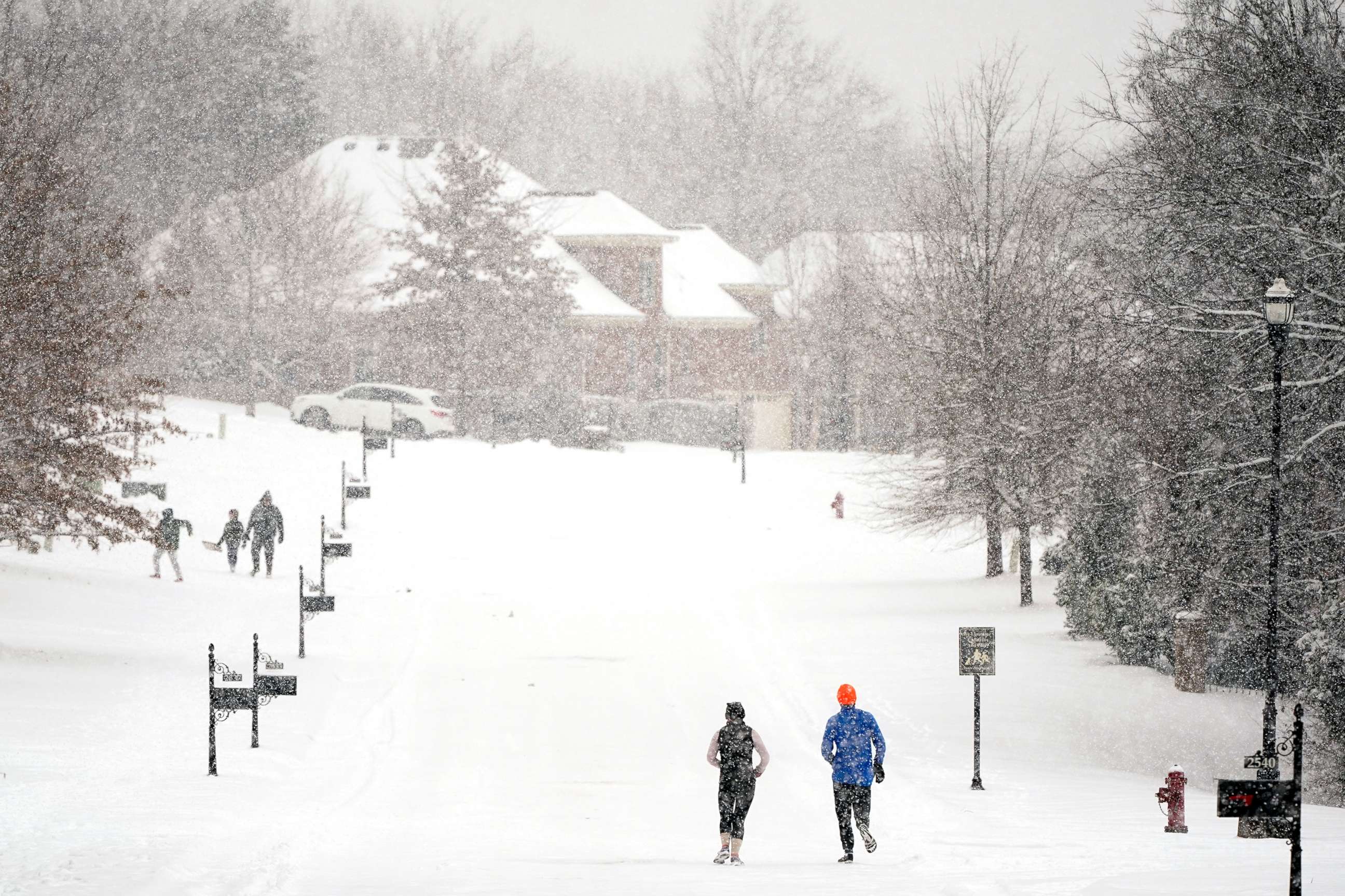 PHOTO: Joggers run down a street as a second winter storm in a week brings more snow, Feb. 18, 2021, in Nolensville, Tenn.