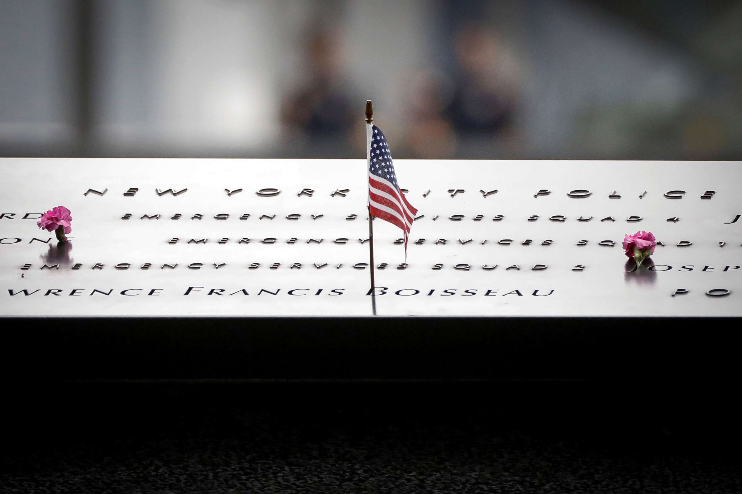 PHOTO: Flowers and a flag are left on names at the National 9/11 Memorial during ceremonies marking the 17th anniversary of the September 11, 2001 attacks on the World Trade Center, in New York, Sept. 11, 2018.