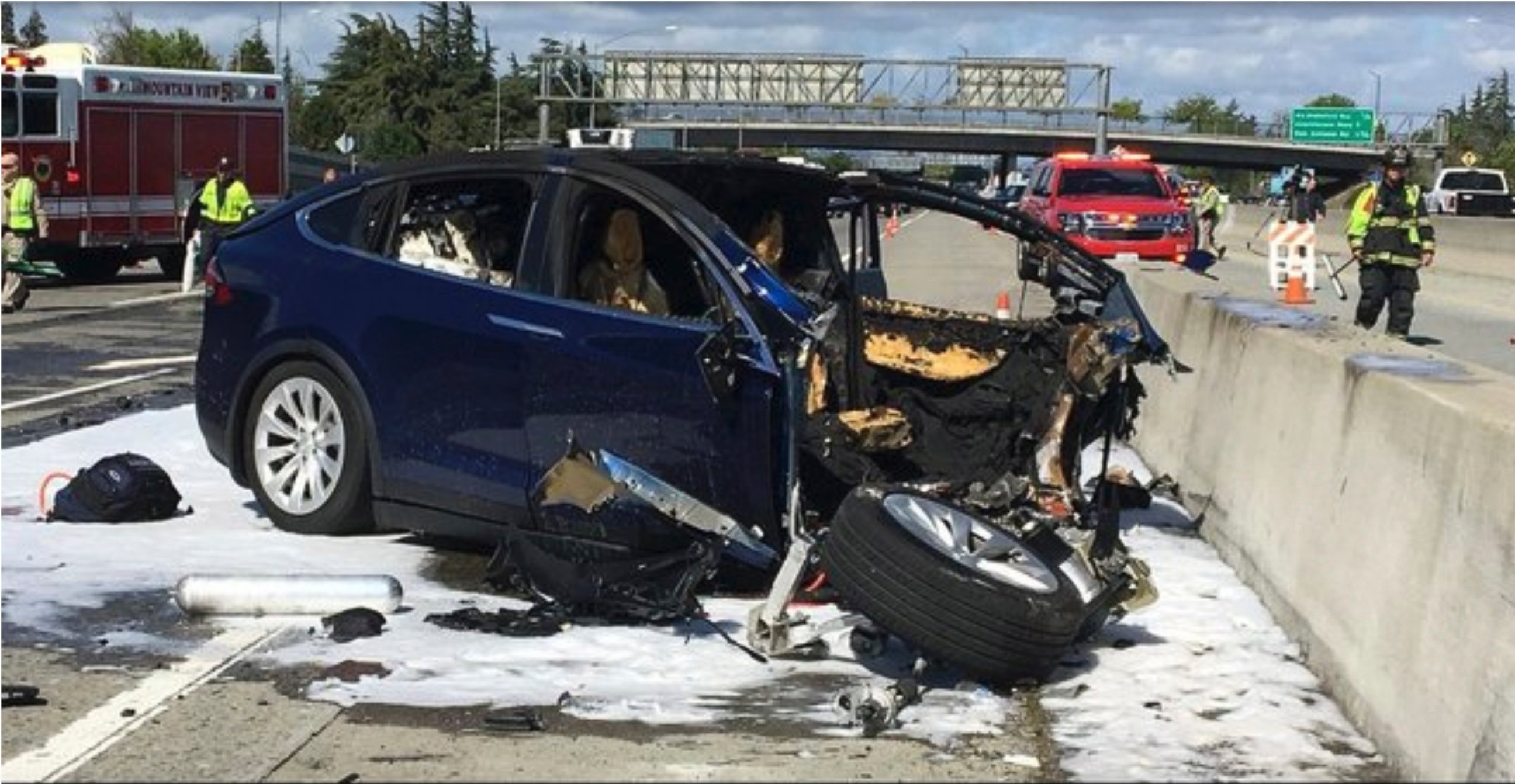 In this Friday March 23, 2018 photo provided by KTVU, emergency personnel work a the scene where a Tesla electric SUV crashed into a barrier on U.S. Highway 101 in Mountain View, Calif.