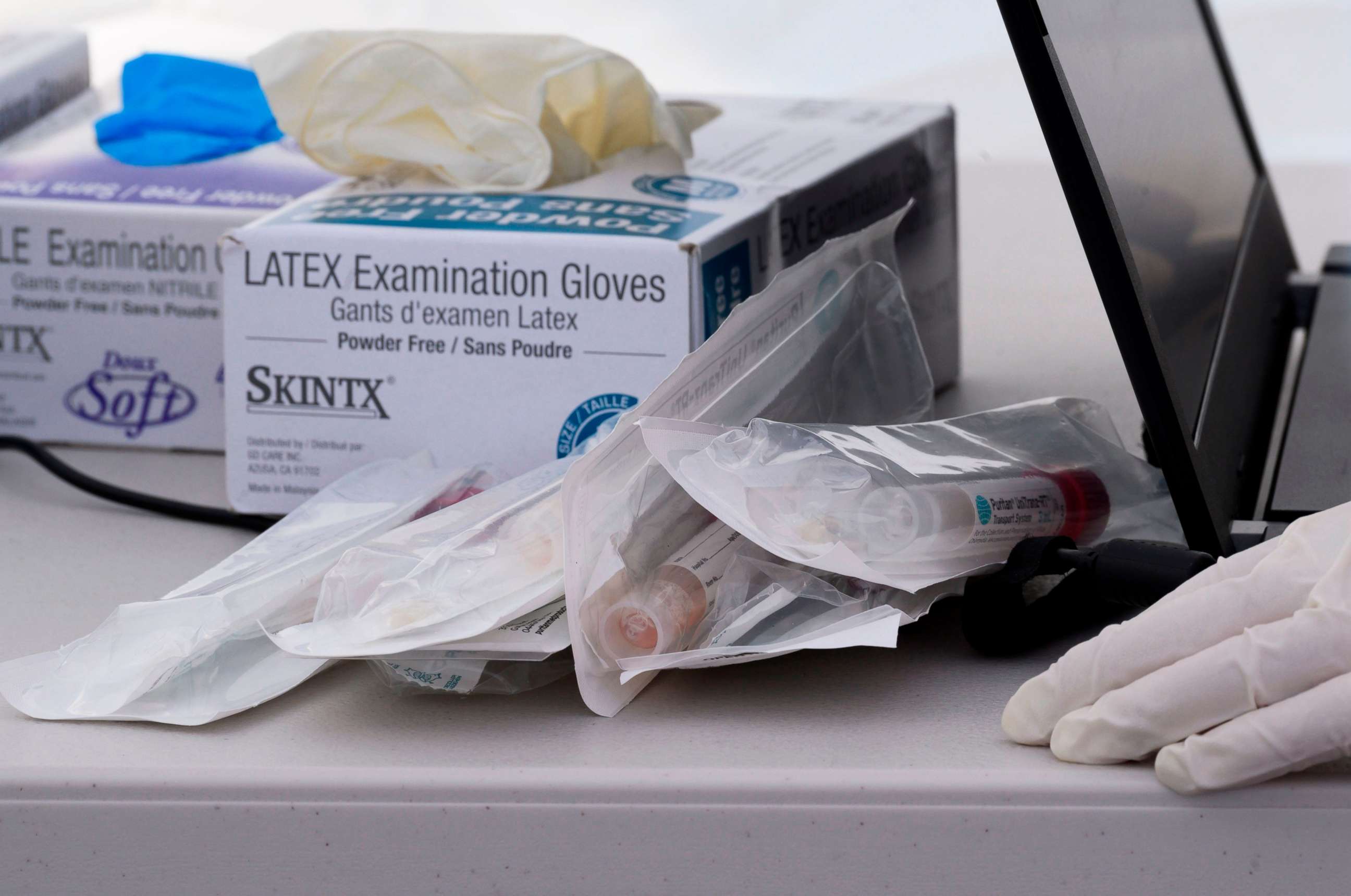 PHOTO: Nasal swab test kits and medical gloves are seen at a COVID-19 testing station in a public school parking area in Compton, California, just south of Los Angeles, on April 28, 2020.