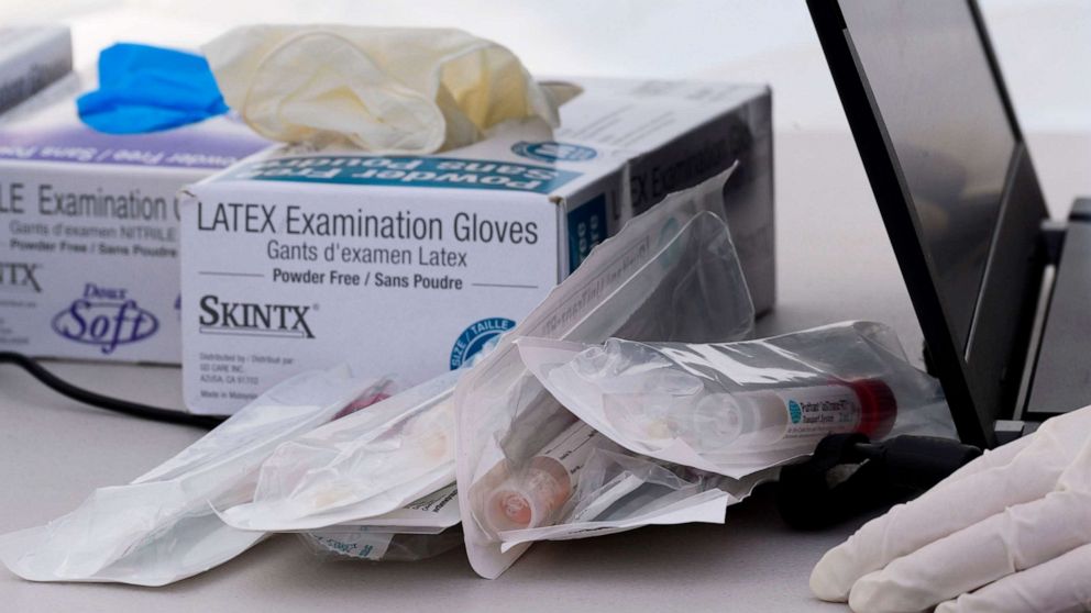 PHOTO: Nasal swab test kits and medical gloves are seen at a COVID-19 testing station in a public school parking area in Compton, California, just south of Los Angeles, on April 28, 2020.