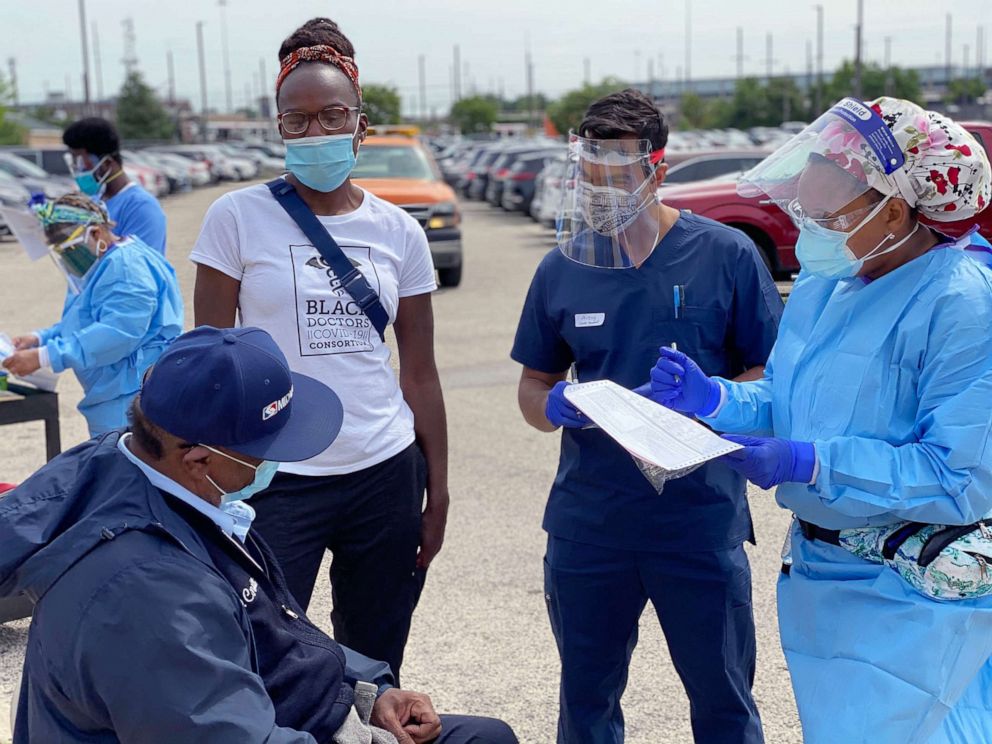 PHOTO: Dr. Ala Stanford, wearing a white t-shirt at left, speaks with a COVID-19 test patient before administering a test in Philadelphia, in June 2020.