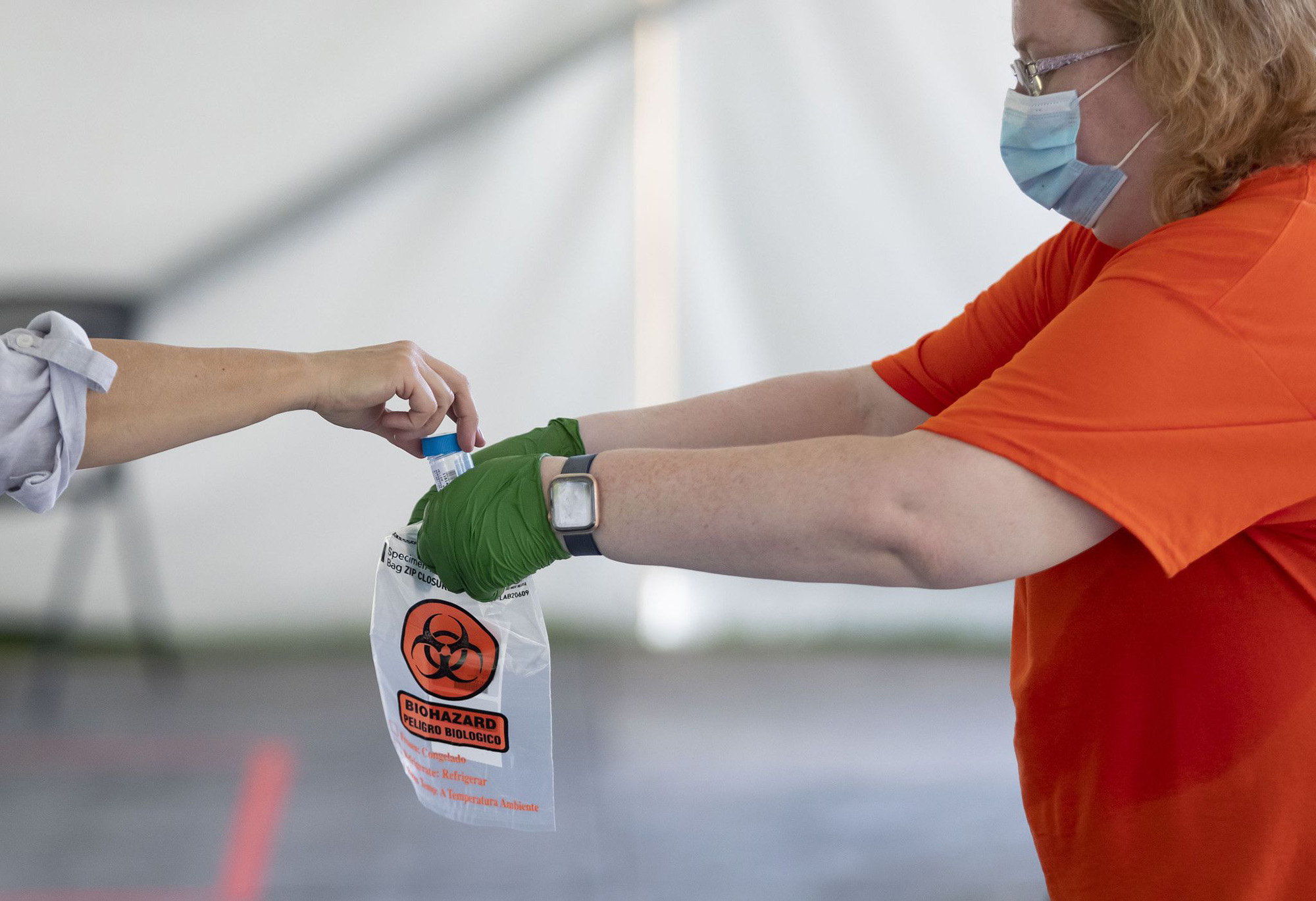 PHOTO: A COVID-19 saliva sample is collected as testing is conducted, July 7, 2020, in a tent on the University of Illinois at Urbana-Champaign campus.