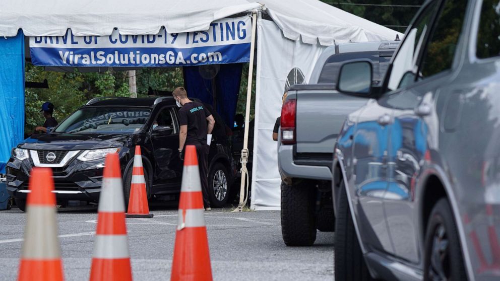 PHOTO: Cars wait in line at a COVID-19 drive-through testing and vaccination site in Marietta, Ga., Aug. 30, 2021.
