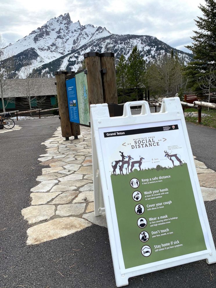 PHOTO: A sign in Grand Teton National Park reminds visitors to keep 6 feet of distance, wash hands, and wear face masks to prevent the spread of COVID-19.