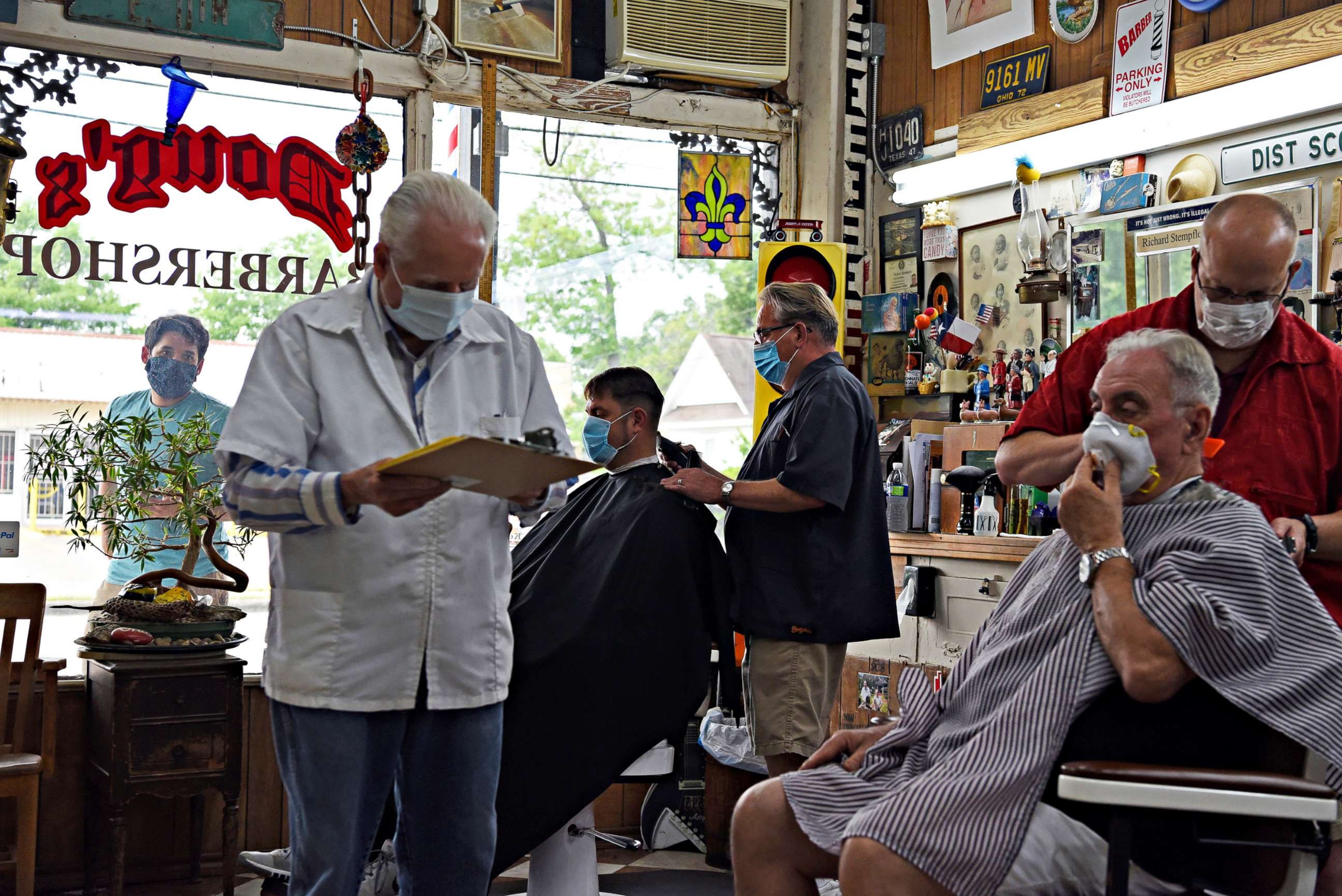 PHOTO: Men receive haircuts as social distancing guidelines to curb the spread of the coronavirus disease (COVID-19) are relaxed at Doug's Barber Shop in Houston, Texas, May 8, 2020.