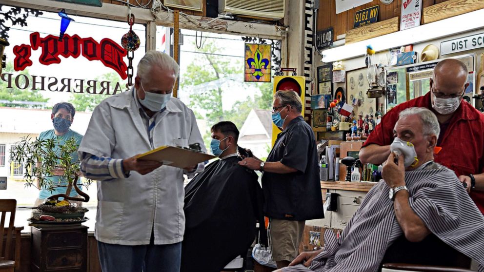 PHOTO: Men receive haircuts as social distancing guidelines to curb the spread of the coronavirus disease (COVID-19) are relaxed at Doug's Barber Shop in Houston, Texas, May 8, 2020.