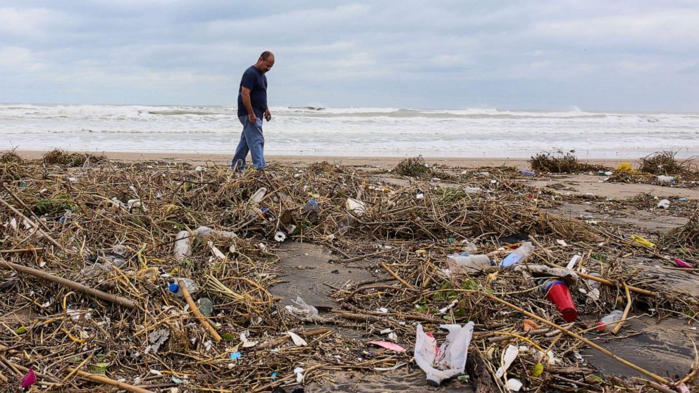 PHOTO: Max Lopez looks for useable items, Sept. 21, 2020, as he walks through piles of trash and debris swept in by outer winds from Tropical Storm Beta over the weekend on Boca Chica Beach outside Brownsville, Texas.