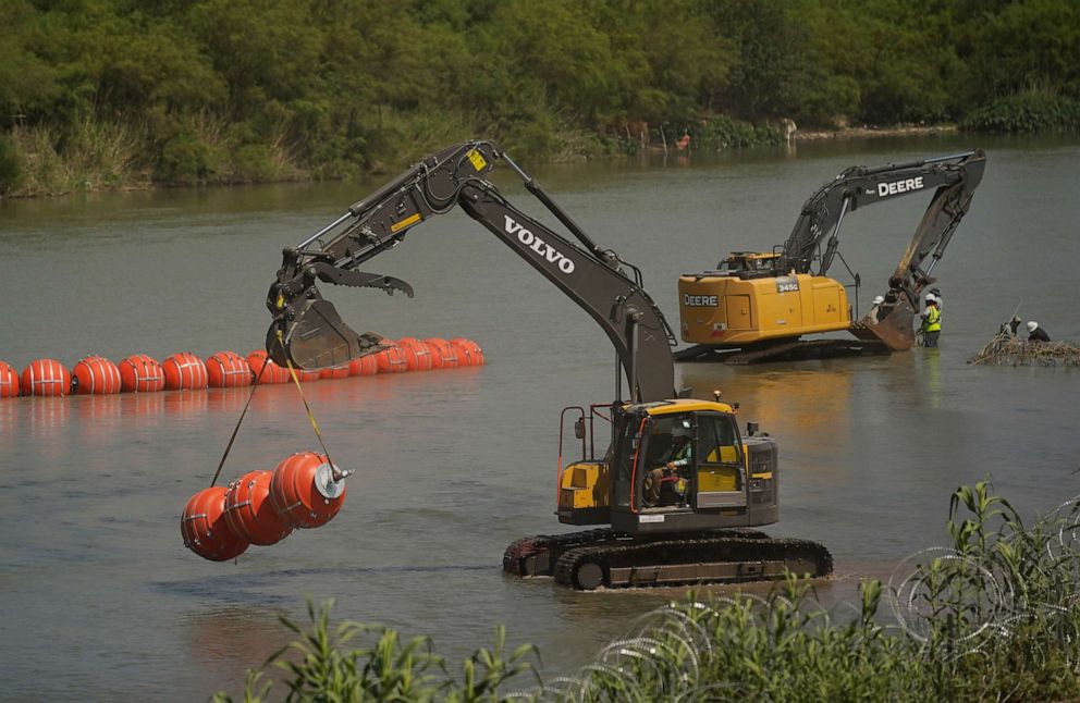 PHOTO: Workers continue to deploy large buoys to be used as a border barrier along the banks of the Rio Grande in Eagle Pass, Texas, Wednesday, July 12, 2023.