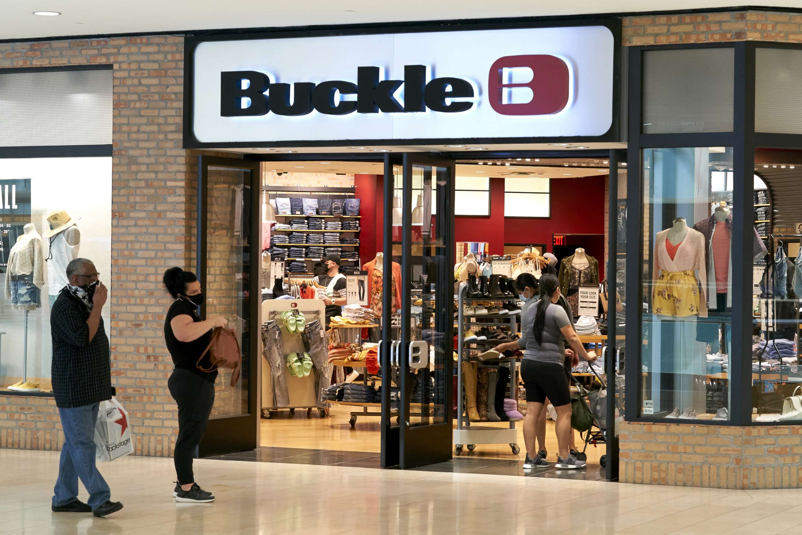 PHOTO: Shoppers wearing protective masks wait in line outside a Buckle store at the Galleria Dallas mall in Dallas, Texas, May 4, 2020.