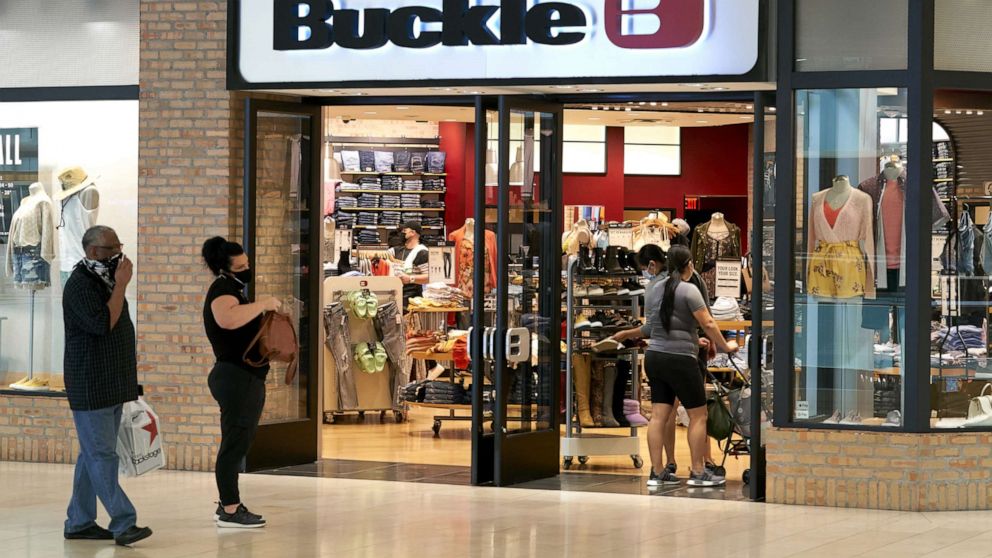 PHOTO: Shoppers wearing protective masks wait in line outside a Buckle store at the Galleria Dallas mall in Dallas, Texas, May 4, 2020.