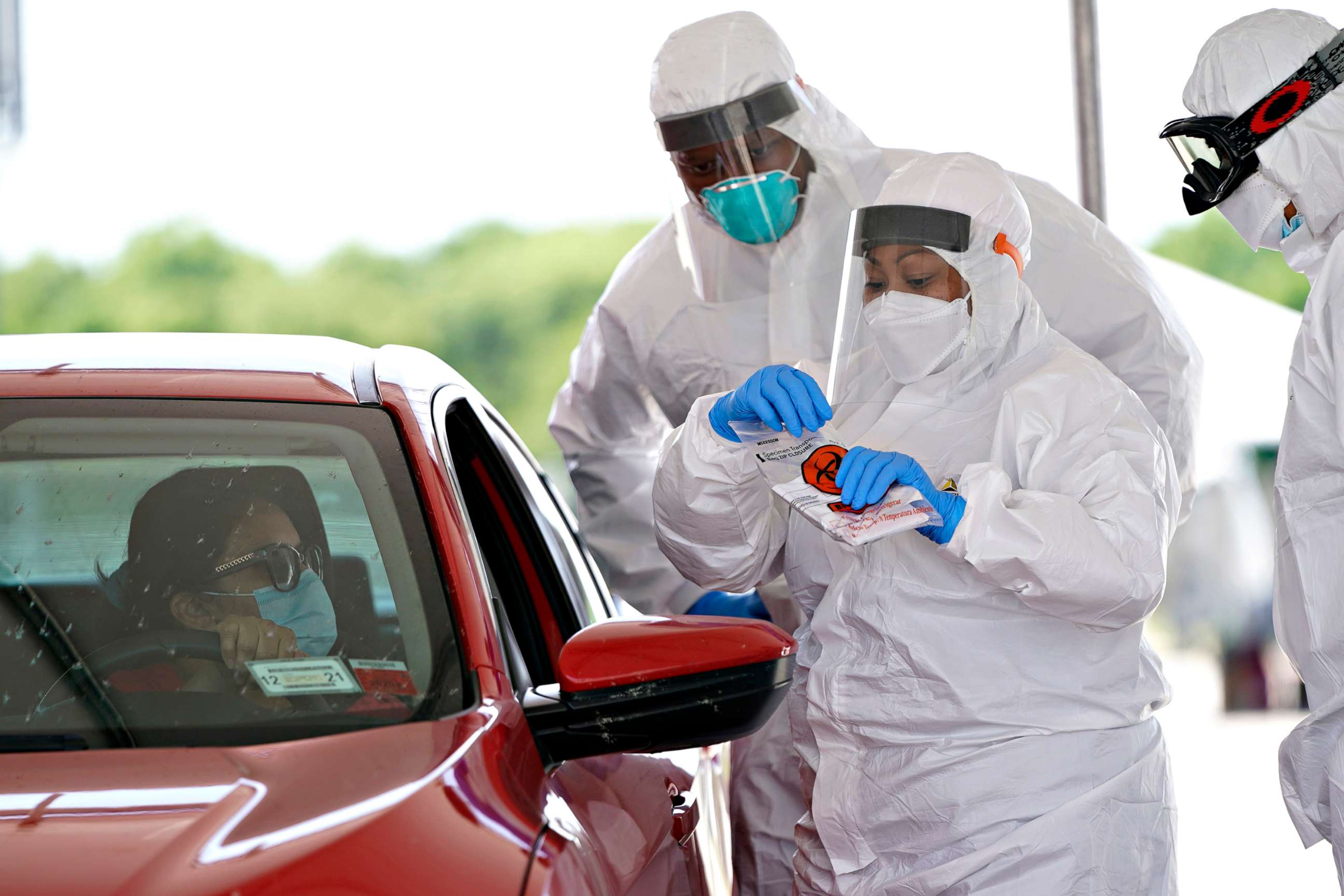 PHOTO: Registered nurse April Lewis, center, prepares to administer a test at a newly opened United Memorial Medical Center COVID-19 drive-thru testing site, April 27, 2020, in Houston.