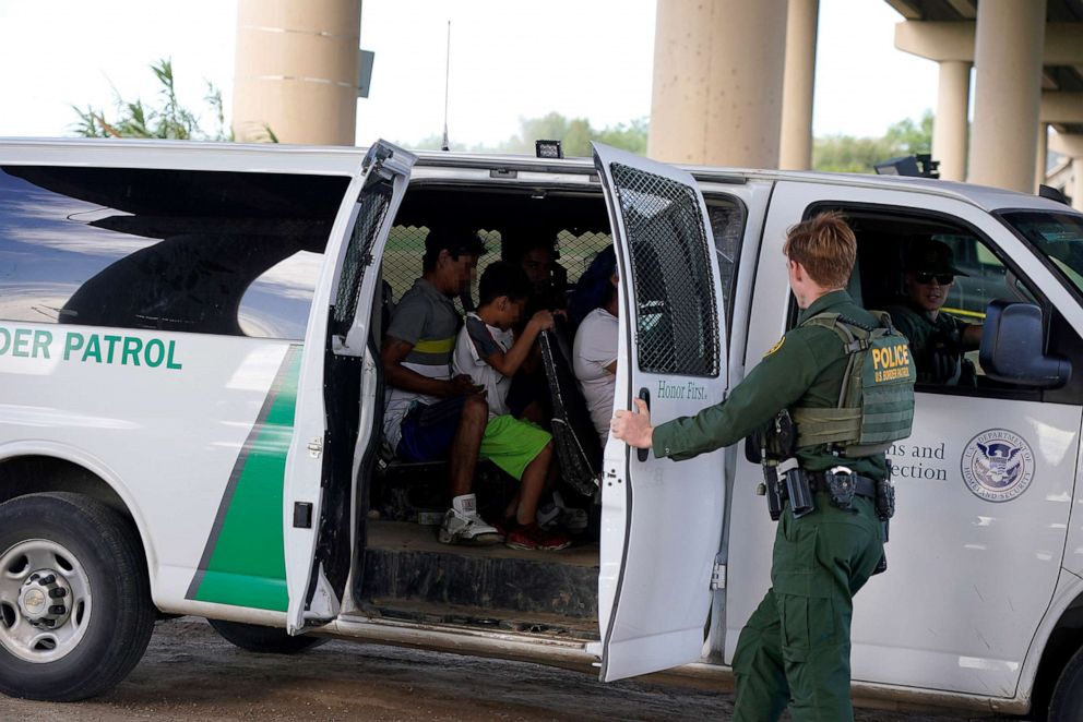 PHOTO: In this May 27, 2022, file photo, migrants that crossed the Rio Grande are loaded into a Border Patrol van before being taken to a detention center in Eagle Pass, Texas.