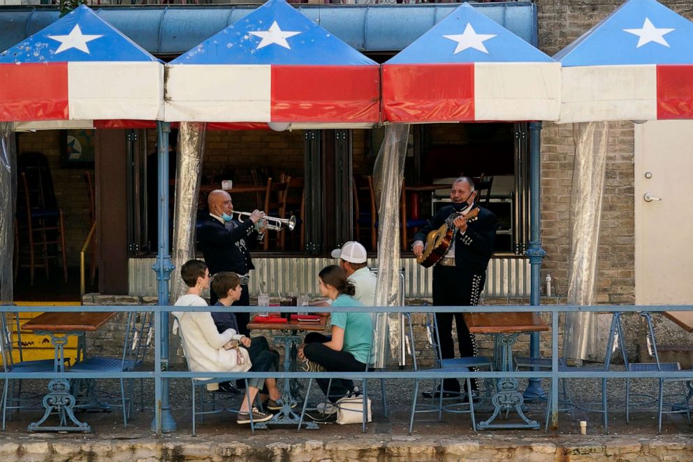 PHOTO: Mariachi perform for diners at a restaurant on the River Walk, March 3, 2021, in San Antonio. Gov. Greg Abbott is lifting a mask mandate and business capacity limits.