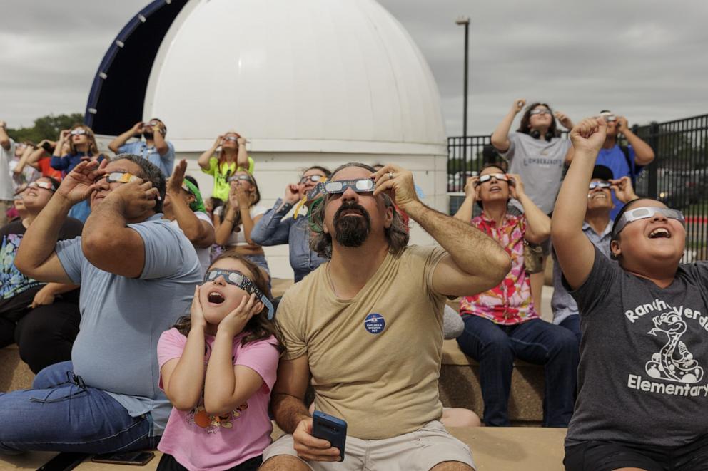 PHOTO: People watch the Annular Solar Eclipse using safety glasses in Brownsville, Texas on Oct. 14, 2023. 