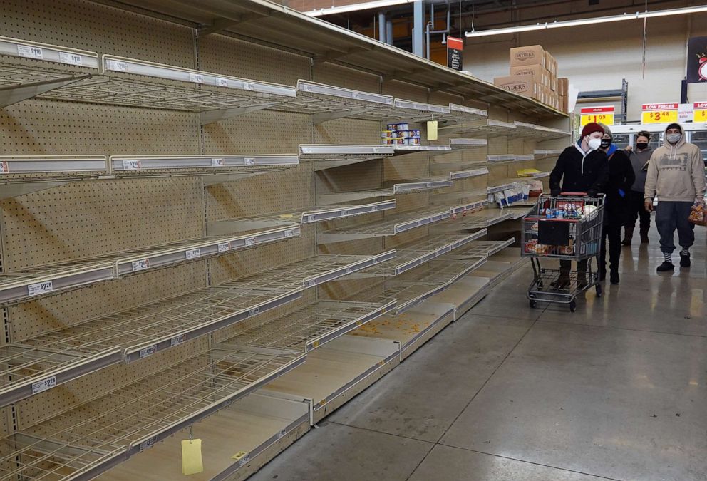 PHOTO: Shoppers walk past a bare shelf at a grocery store, Feb.18, 2021, in Austin, Texas.