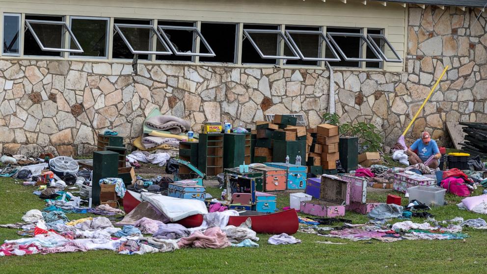 PHOTO: A woman inspects campers' belongings lying on the ground following flooding on the Guadalupe River, at Camp Mystic, in Hunt, Texas, July 9, 2025.