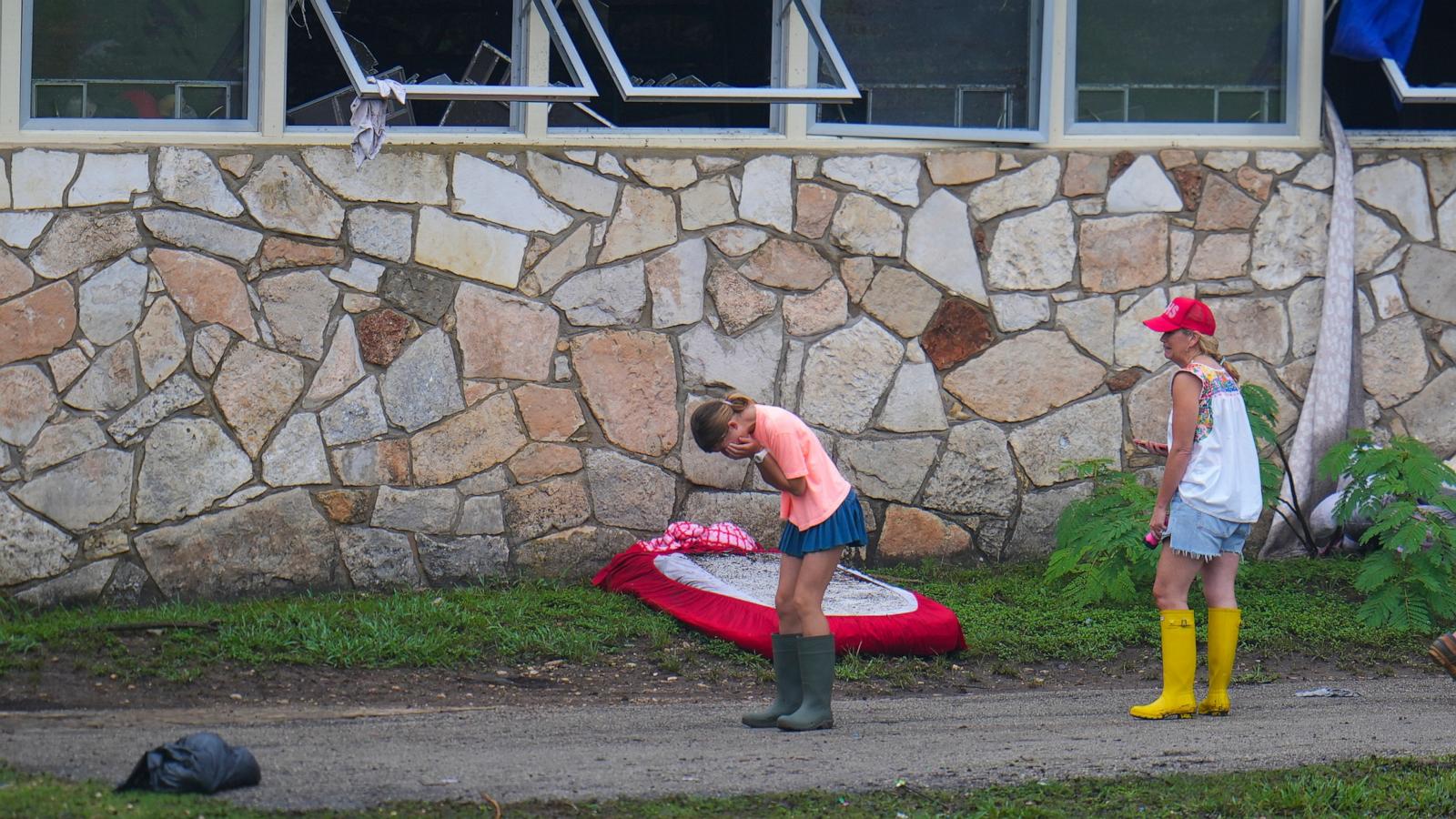 People react as they inspect an area outside sleeping quarters at Camp Mystic along the banks of the Guadalupe River after a flash flood swept through the area, July 6, 2025, in Hunt, Texas. 