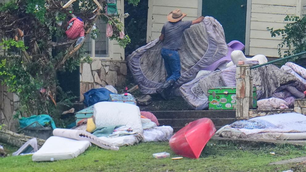 PHOTO: A person removes bedding from sleeping quarters at Camp Mystic along the banks of the Guadalupe River, July 6, 2025, in Hunt, Texas.