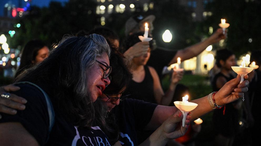 PHOTO: A woman cries as she is embraced by another person during a vigil for the victims of the floods over Fourth of July weekend, at Travis Park, in San Antonio, Texas, July 7, 2025.