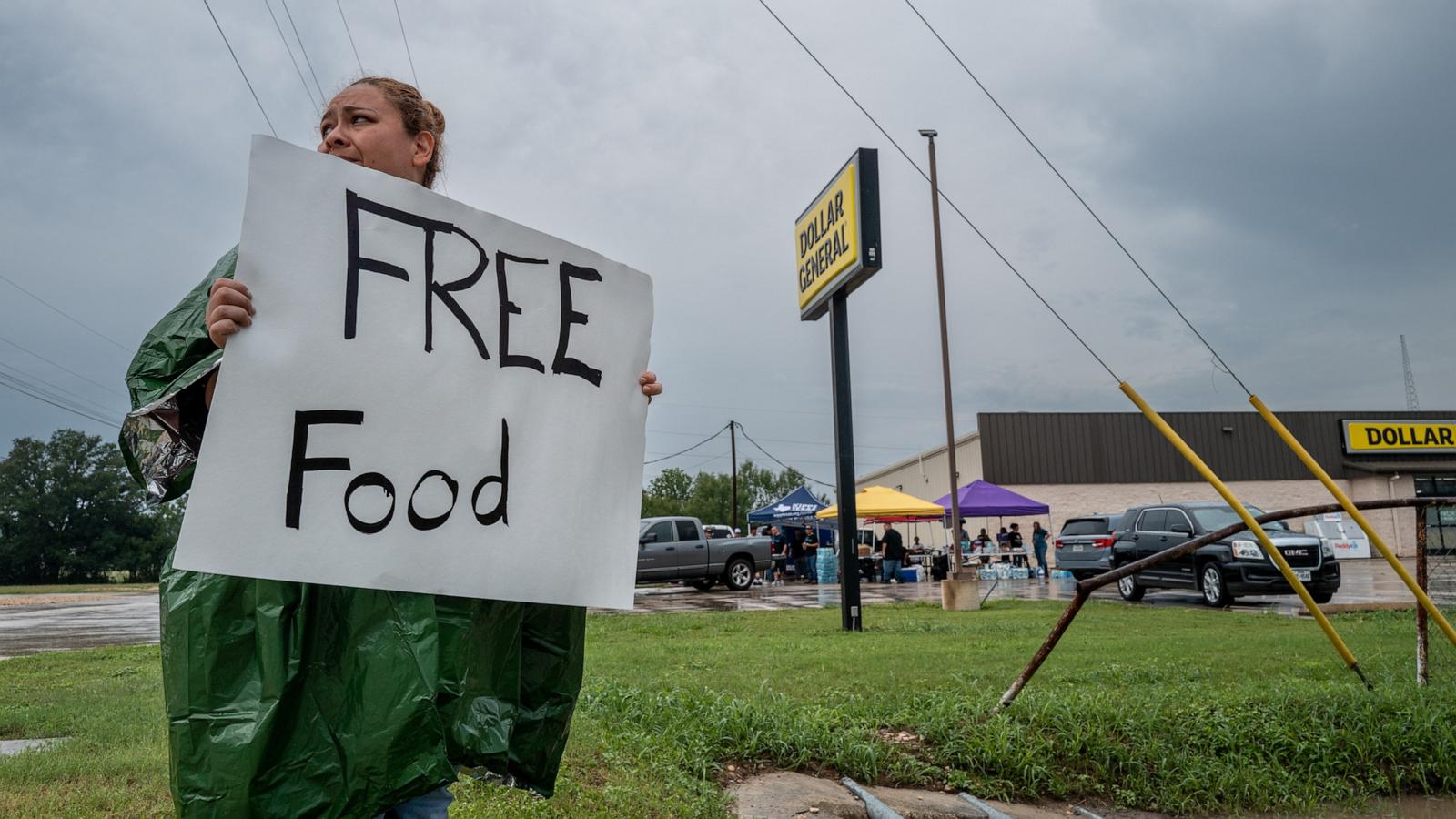 PHOTO: A volunteer displays a sign for free food for people in need of relief, July 6, 2025 in Center Point, Texas
