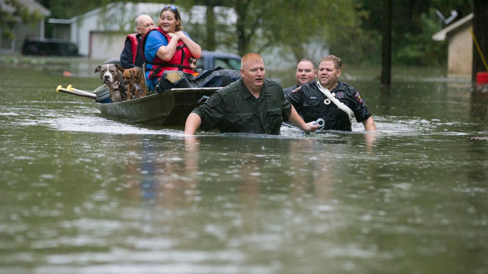 PHOTO: Splendora Police Lt. Troy Teller, left, Cpl. Jacob Rutherford and Mike Jones pull a boat carrying Anita McFadden and Fred Stewart from their flooded neighborhood on Sept. 19, 2019, in Spendora, Texas.