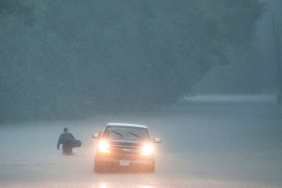 PHOTO: A man walks into high water into his neighborhood as rain from Tropical Depression Imelda inundated the area on Sept. 19, 2019, near Patton Village, Texas.