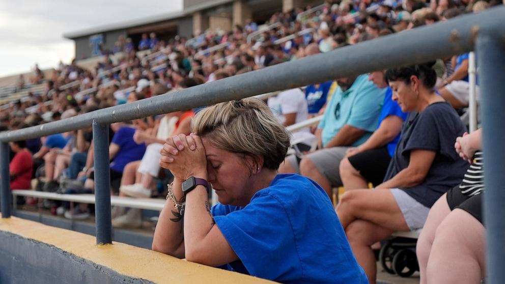 PHOTO: A woman prays during a vigil for flooding victims at Tivy Antler Stadium, July 9, 2025, in Kerrville, Texas.
