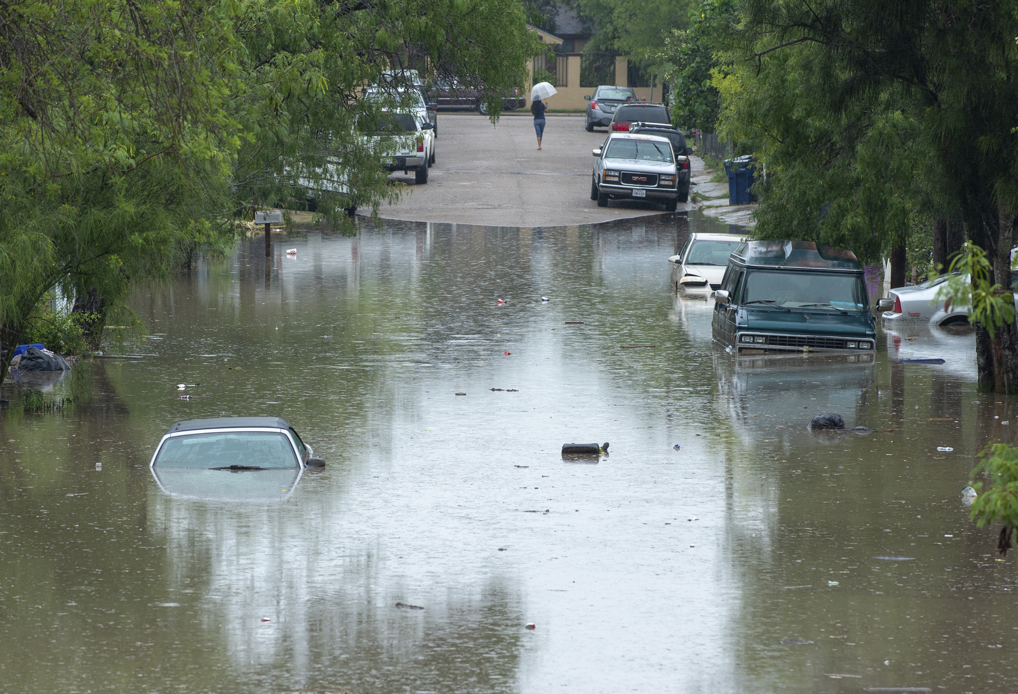 PHOTO: A woman walks back to higher ground, June 20, 2018, in Mercedes, Texas.