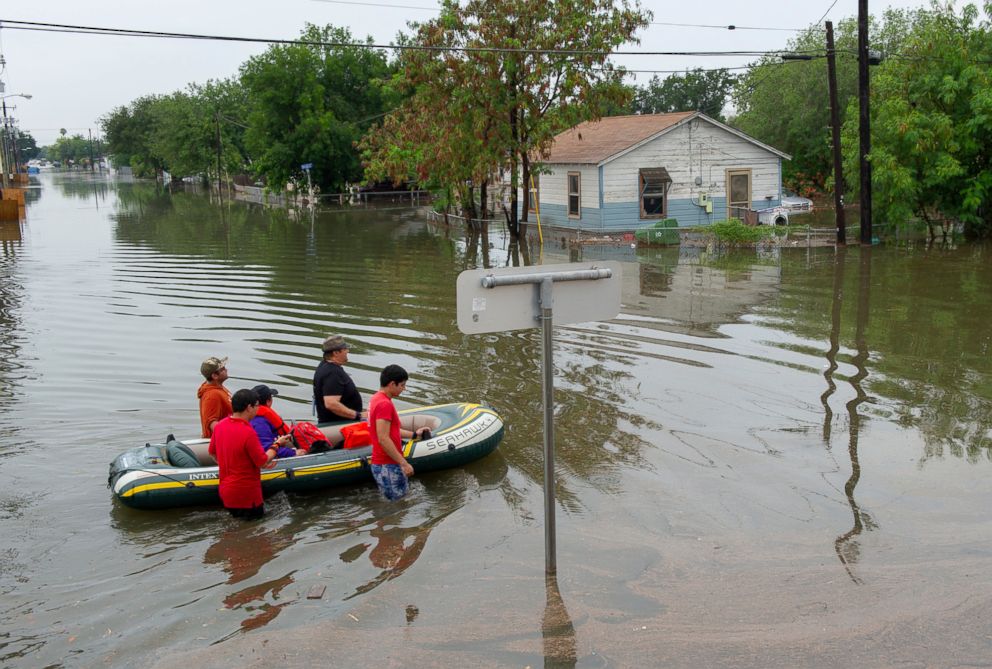 PHOTO: A woman is evacuated by volunteers in devastating floodwaters, June 20, 2018, in Weslaco, Texas.