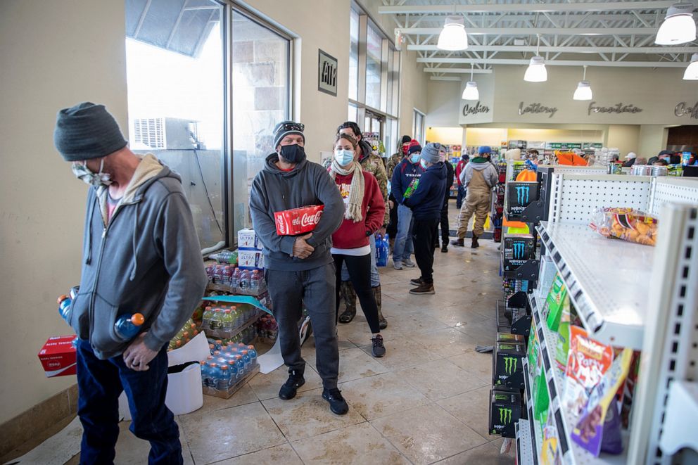 PHOTO: Customers, whose homes are without electric power, wait in line to purchase food and snacks at a gas station in Pflugerville, Texas, Feb. 16, 2021.