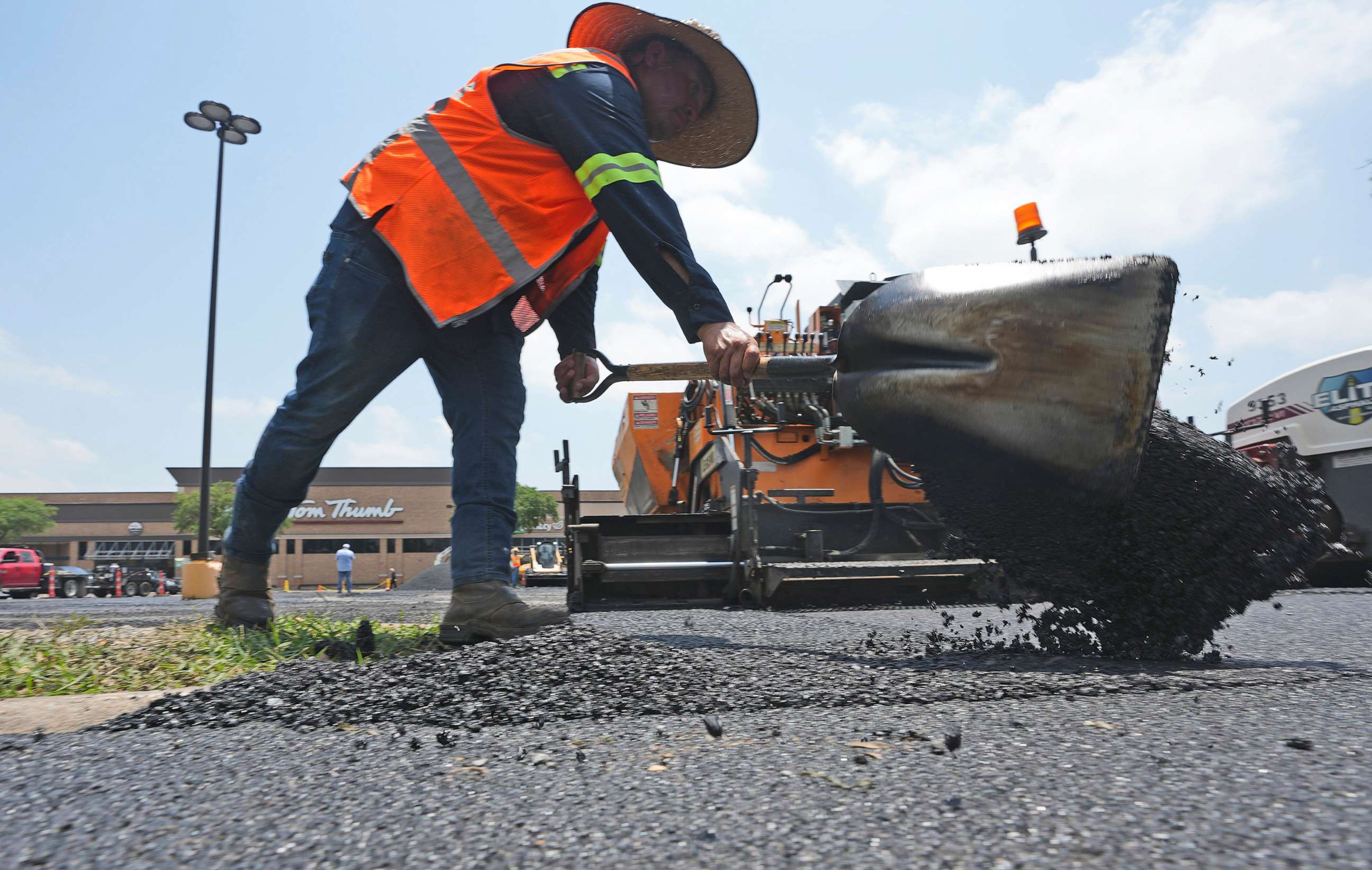 PHOTO: Miguel shovels hot asphalt during a parking lot resurfacing job in Richardson, Texas, June 20, 2023.