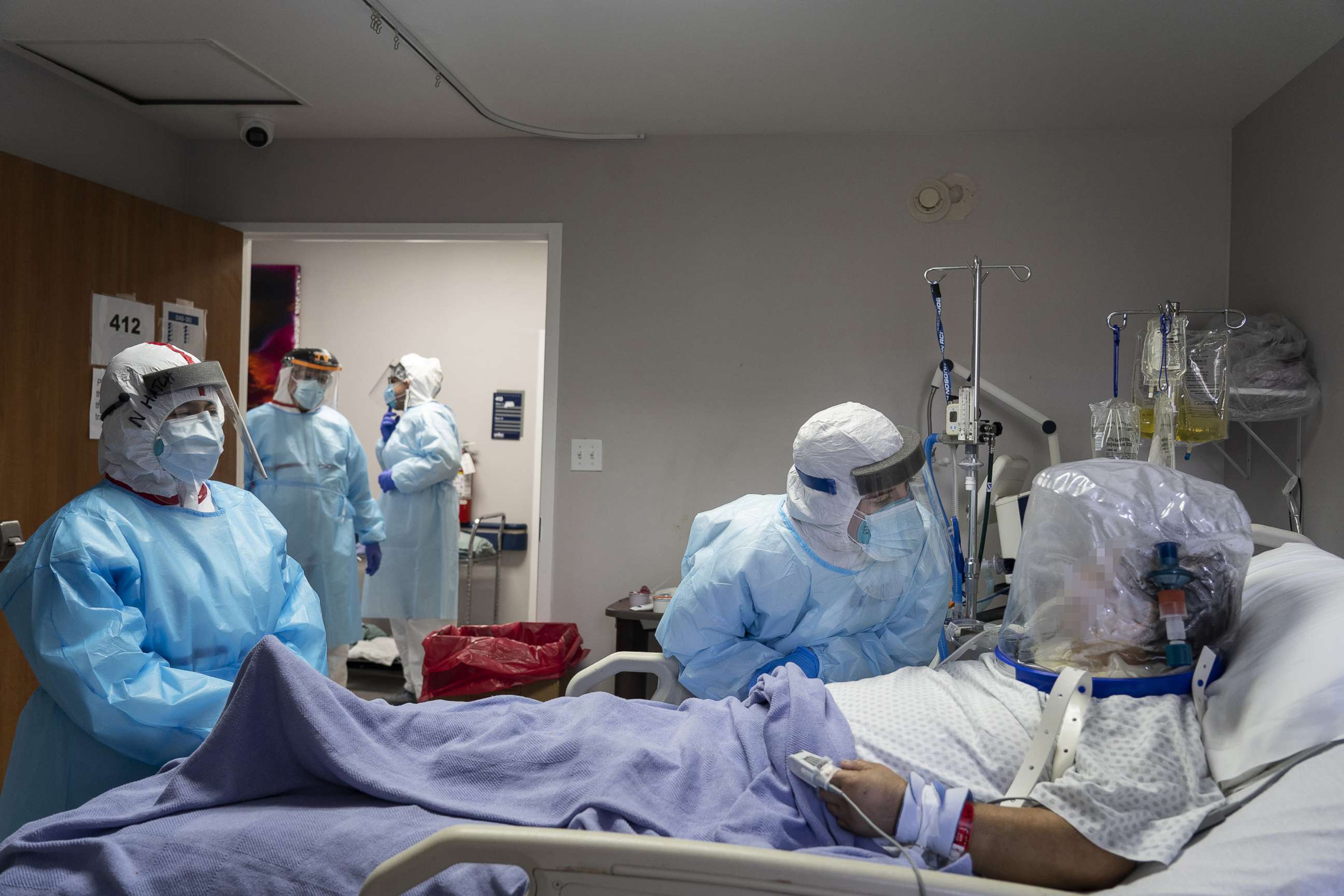 PHOTO: Members of the medical staff treat a patient who is wearing helmet-based ventilator in the COVID-19 intensive care unit at the United Memorial Medical Center on July 28, 2020, in Houston.