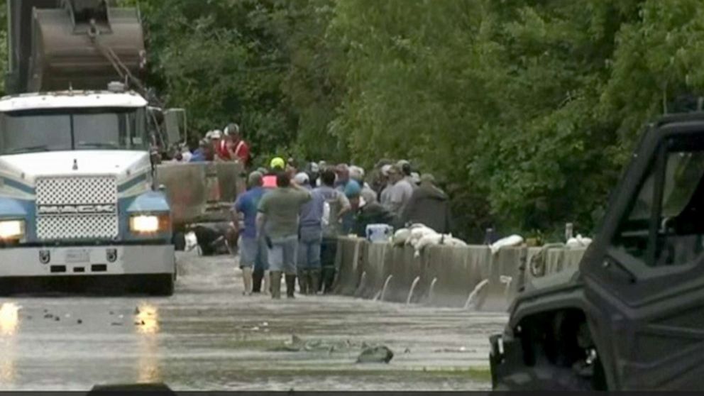 PHOTO: Volunteers try to get flooding under control after a temporary dam failure in Louisiana, May 21, 2021.