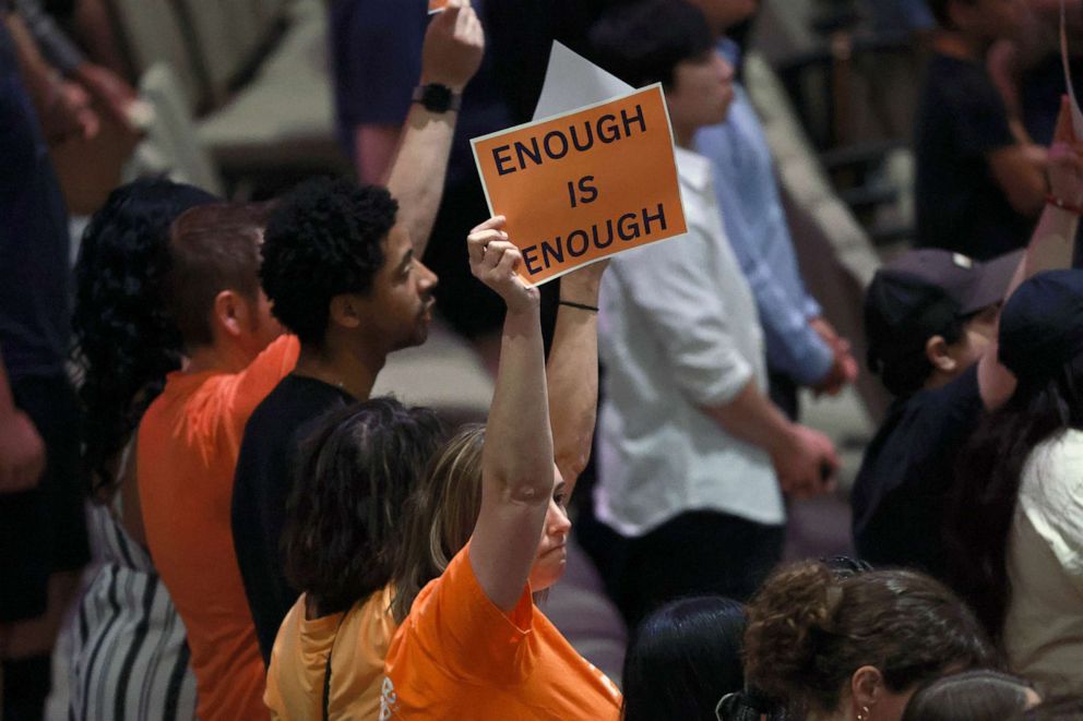 PHOTO: People hold signs reading ' Enough is Enough' as they attend a vigil, May 7, 2023 in Allen, Texas.