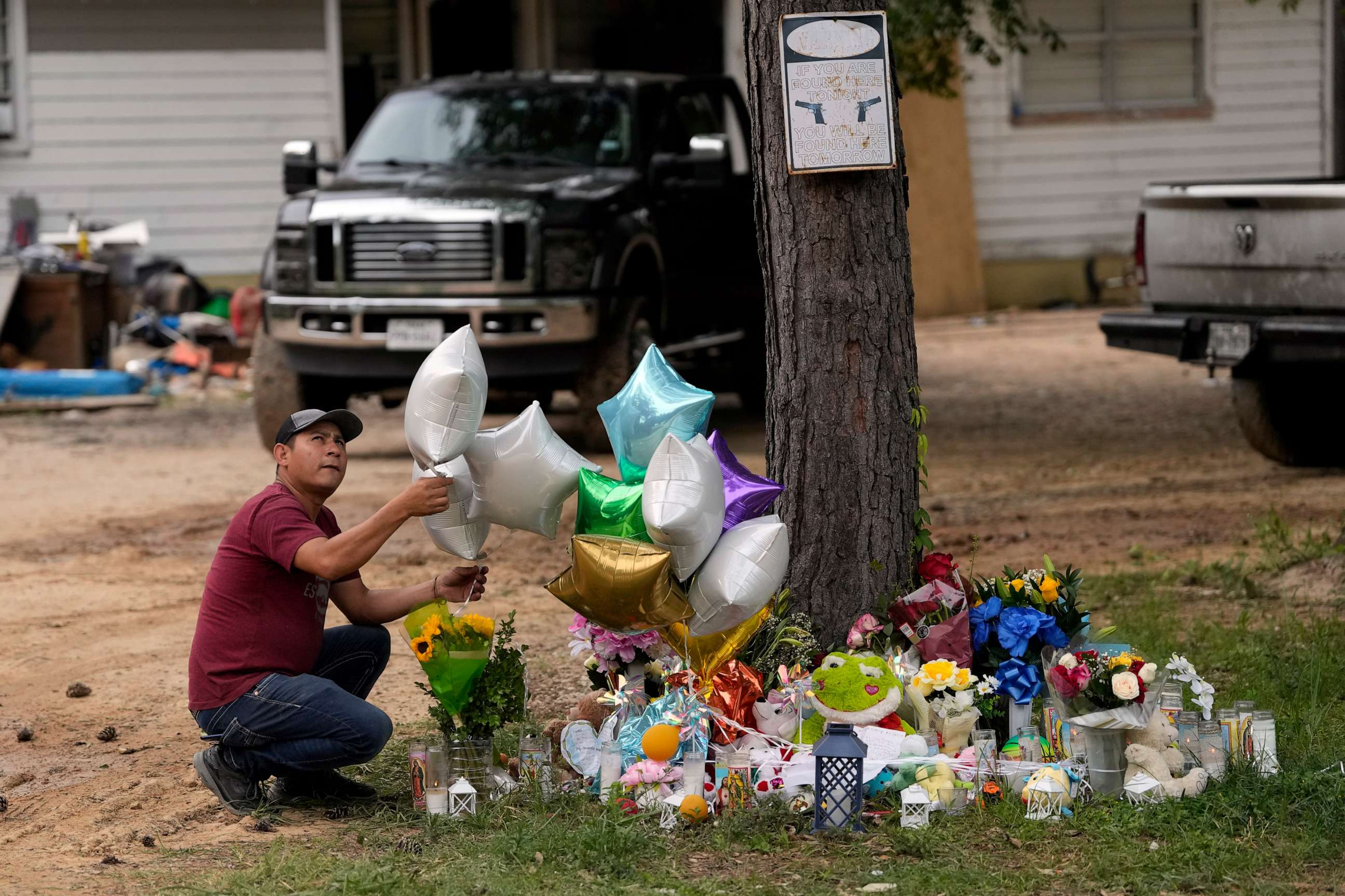 PHOTO: A man releases a balloon from the makeshift memorial outside the victims' home, May 2, 2023, where a mass shooting occurred Friday, in Cleveland, Texas.