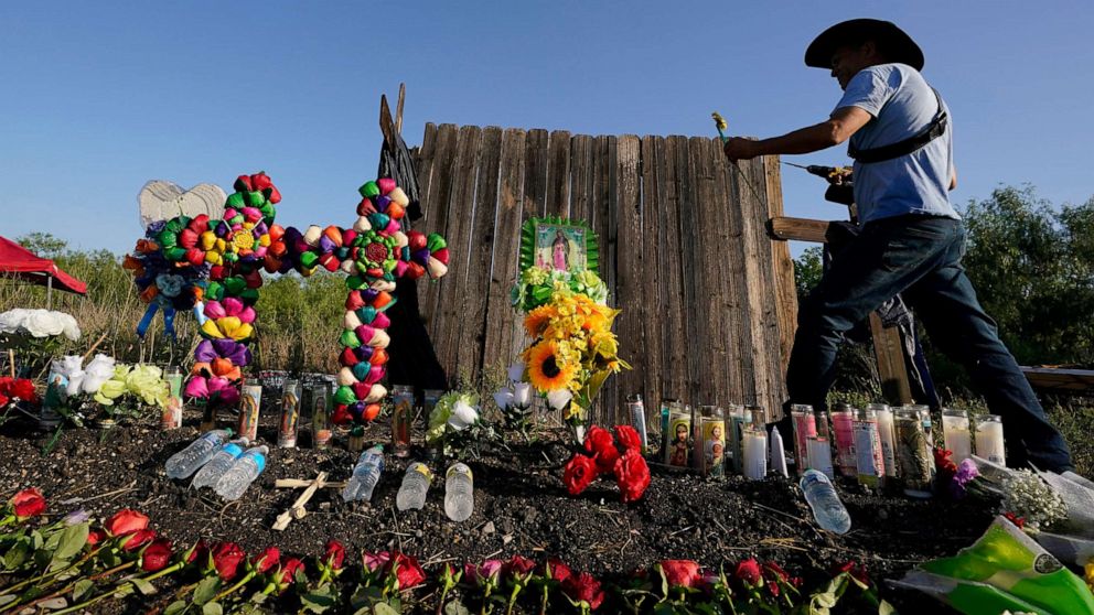 PHOTO: Roberto Marquez of Dallas adds a flower a make-shift memorial at the site where officials found dozens of people dead in an abandoned semitrailer containing suspected migrants in in San Antonio, Texas, June 29, 2022.