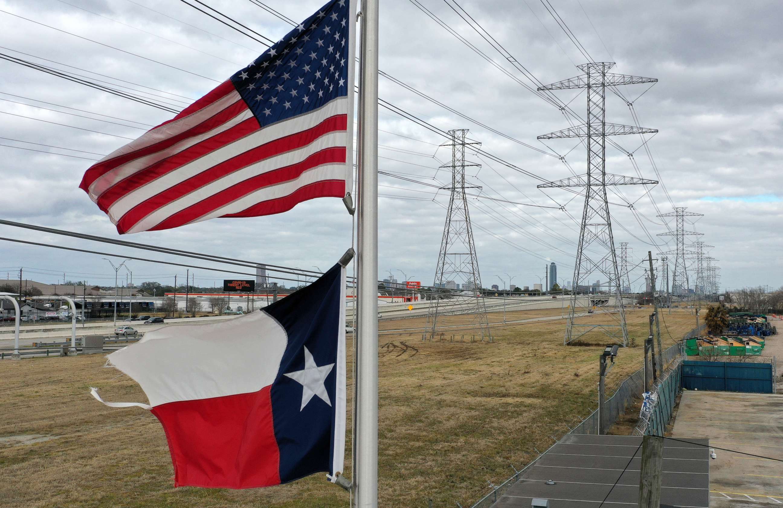 PHOTO: The U.S. and Texas flags fly in front of high voltage transmission towers on Feb. 21, 2021 in Houston, Texas. 